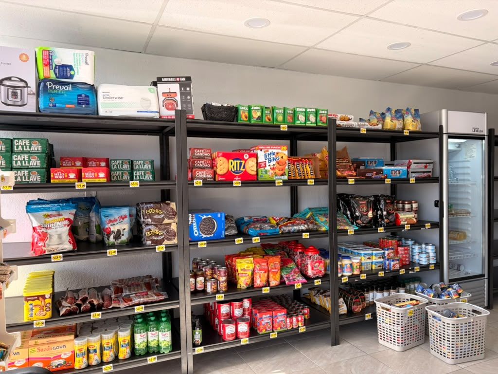 Estantes surtidos dentro del local: Café La Llave, galletas, enlatados y nevera de bebidas